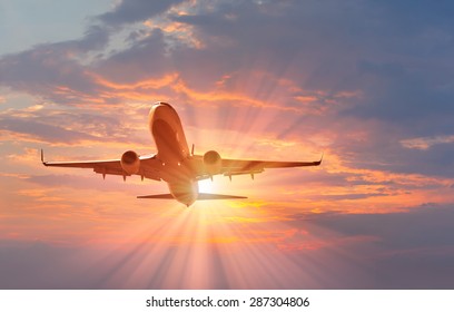 passenger plane fly down over take-off at sunset