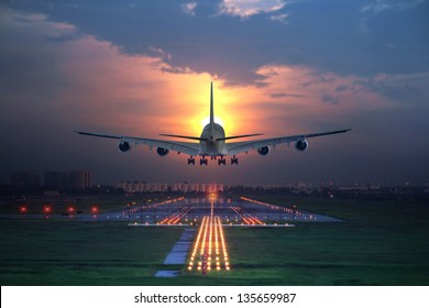passenger plane fly up over take-off runway from airport at sunset