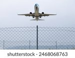 Passenger plane flying behind barbed wire. Aviation idea concept. Deported. International travel. Airplane taking off. Horizontal photo. No people, nobody. Travel. Abroad.