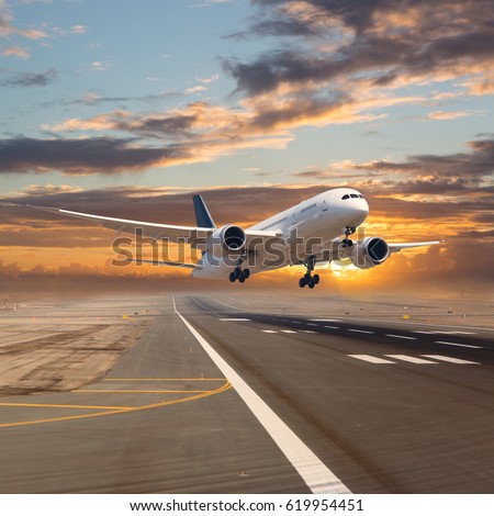 A passenger plane flying in the colorful sky. Aircraft takes off from the airport runway during the sunset.