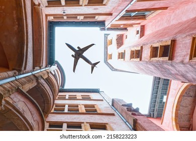 A passenger plane flying top of the houses - Bottom view of typical lyon historic buildings - Typical narrow cobbled street - Lyon, France
