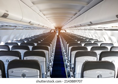 Passenger Plane Interior. Empty Airplane Interior With Chairs And Folding Tables In Seat Back. Cabin Of Passenger Aircraft, Economy Class Or Salon In Jet.