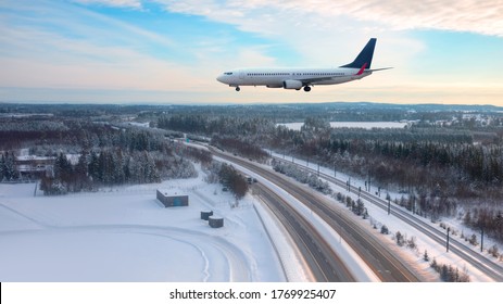 A Passenger Plane Landing At Oslo Gardermoen International Airport - Airport In A Snow Covered - Beautiful Winter Landscape With Aerial View Of Highway Road And Snow-covered Road