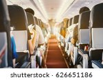 passenger seat, Interior of airplane with passengers sitting on seats and stewardess walking the aisle in background. Travel concept,vintage color,selective focus