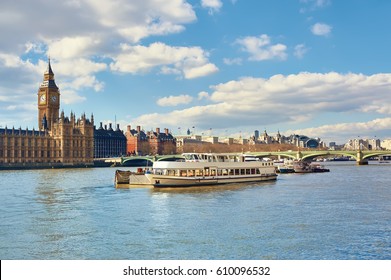 Passenger ships and service boats in front of Parliament of London, UK, on a bright day