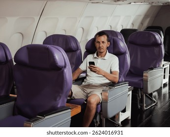 Passenger sitting alone in a nearly empty airplane cabin