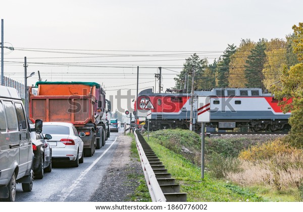Passenger\
train crosses the highway at autumn day\
time.