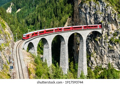 Passenger train crossing the Landwasser Viaduct in the Swiss Alps - Shutterstock ID 1917593744