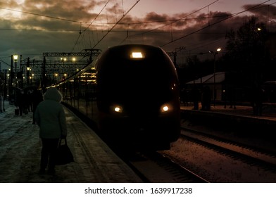 Passenger train in motion. Arrival to station, evening time, passengers on railway perron, transportation system. Dark silhouette of train. Vintage style Image with blur effect