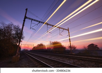 Passenger Train On Railroad Tracks At The Sunrise - Blurred Motion