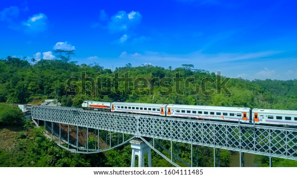 A Passenger Train\
Passing by Cirahong Bridge, A Double Deck Structure of Metal\
Railway Bridge and Car Bridge Underneath Made by Dutch Colonial,\
Tasikmalaya, Indonesia