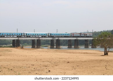 Passenger train passing through a bridge over the river