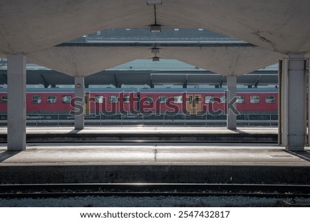 Passenger train resting on platform in Ljubljana, Slovenia, between the concrete canopies over track on sunny autumn day, just before renovation of station...