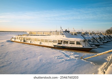 passenger transport vessels moored for the winter near the pier are all covered in snow frozen river - Powered by Shutterstock