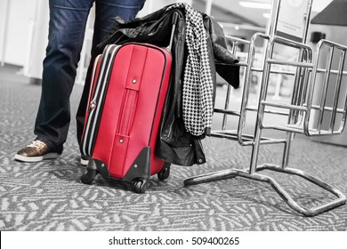 Passenger With Travel Suitcase And Jacket At The Airport Boarding Area