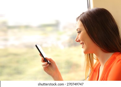 Passenger using a mobile phone in a train or bus beside the window