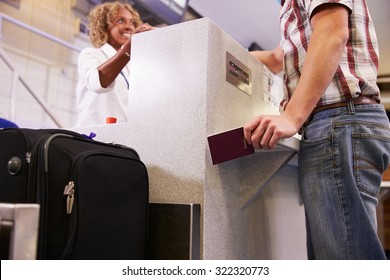 Passenger Weighing Luggage At Airport Check In