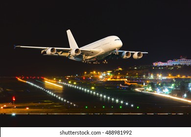 Passenger Wide Body Aircraft. The Plane Takes Off From The Airport Runway At Night.