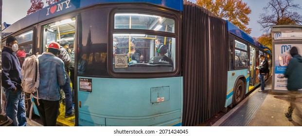 Passengers In Coats Entering The Doors In MTA Bus On A Bus Stop At Night, White Plains Road And Pelham Parkway, New York, Very Wide Shoot Panorama,  Bronx, United States Of America, 11.08.2021