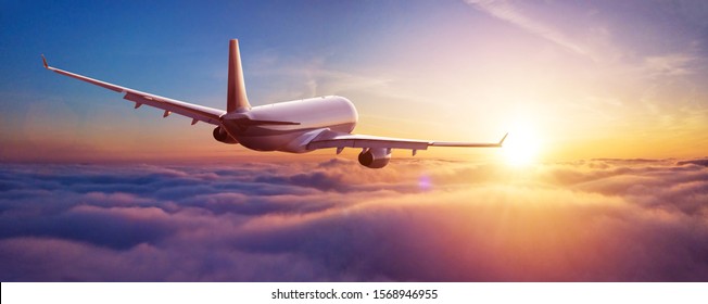 Passengers commercial airplane flying above clouds in sunset light. Concept of fast travel, holidays and business. - Shutterstock ID 1568946955