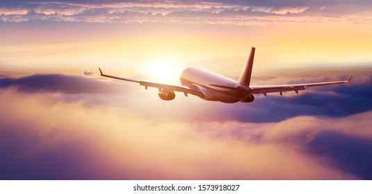 Passengers commercial airplane flying above clouds in sunset light. Concept of fast travel, holidays and business. - Shutterstock ID 1573918027