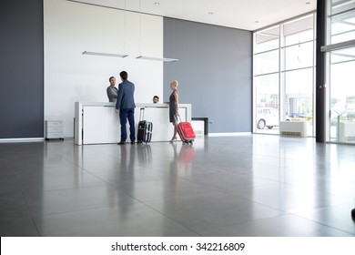 Passengers Departing From Business Trip At Hotel Reception 