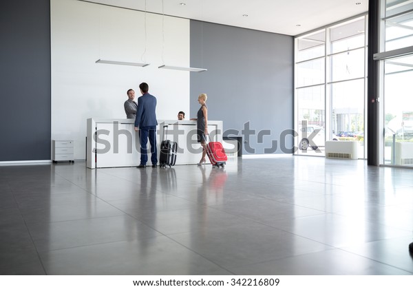 Passengers departing from business trip at hotel\
reception 