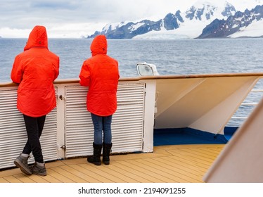 Passengers In Red Parkas On An Antarctic Expedition At The Bow Of A Ship	
