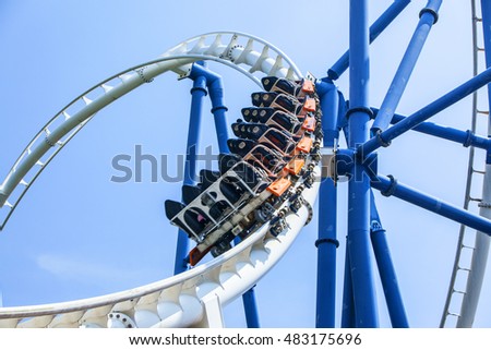 passengers restrained in seats of steel roller coaster trains climbing to a higher position