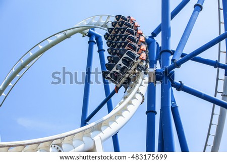 passengers restrained in seats of steel roller coaster trains climbing to a higher position