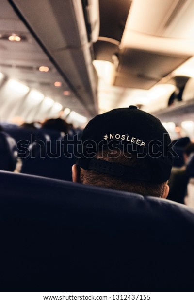 Passengers\
seated in airplane seats before take off.\
