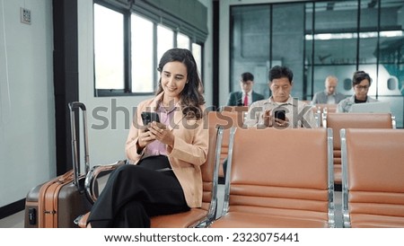 The passengers, tourist using smartphone while sitting on chair in terminal hall waiting flight in the departure gate at international airport. Travel concept