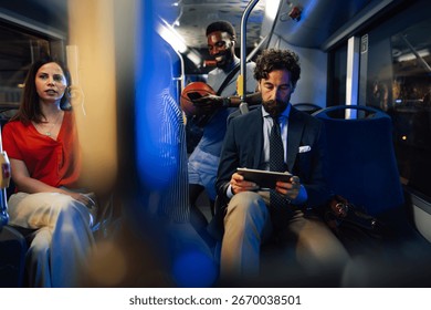 Passengers using smartphones and tablets while commuting on a night bus, showcasing modern connectivity and urban lifestyles