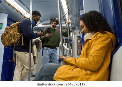Passengers using their smartphones while traveling on a subway train, engrossed in their digital world
