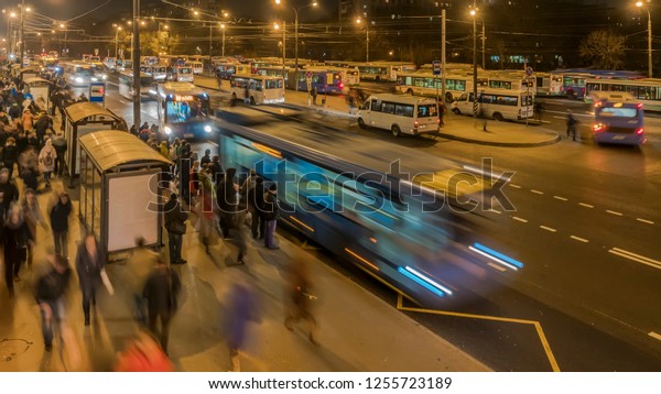 passengers waiting and boarding buses at the\
bus terminal,