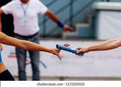 passing of baton from hand to hand women relay race