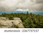 Passing dark rain cloud floating by, seen from the granite summit of Mt. Kearsarge, at Winslow State Park in Wilmot, New Hampshire