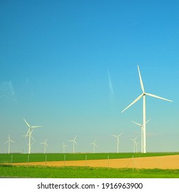 Passing Through Wind Turbine On The Green Field Somewhere In France To Euro Tunnel.