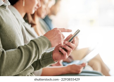 Passing time during the wait. Cropped shot of an unrecognisable group of businesspeople sitting in a row and using technology.