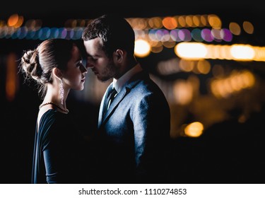 Passion Couple In Love Stands Against The Lights Of A Night City, Hugs Kisses 