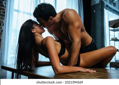 Passion, dating and love. Young beautiful sexy couple have  sex on kitchen table in home.  Sensual relationship.