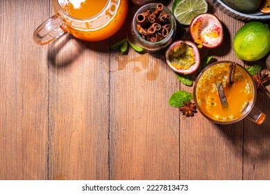 Passion fruit hot tea drink with fruity juice, cinnamon, lime, over wooden background with fresh passion fruit and spices - Shutterstock ID 2227813473