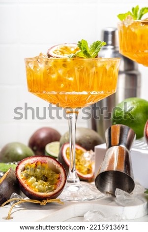 Passion fruit martini cocktail. Sweet pornstar alcoholic drink with fresh passion fruit and lime, with bar utensils copy space