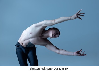 Passion. Portrait of young man, flexible male ballet dancer dancing isolated on old navy studio background. Art, motion, action, flexibility, inspiration concept. Flexible artist. Beauty of male body