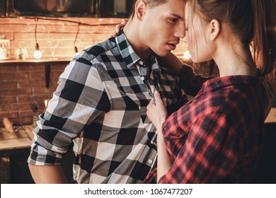 Passion, sex, love concept. Beautiful playfuly woman want kiss man. Indoor, kitchen home interior, studio shot.