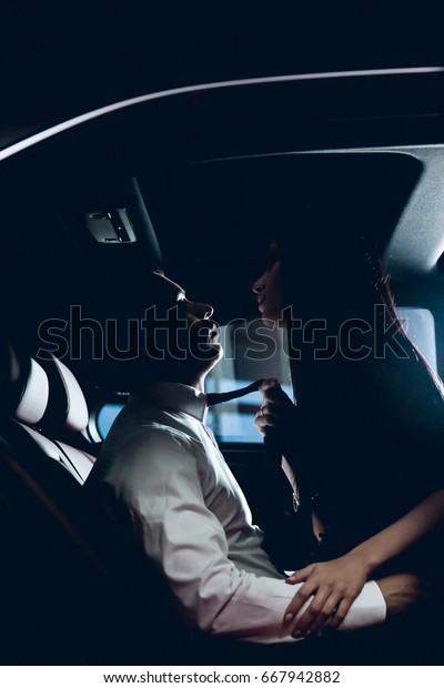 Passionate couple in the\
back seat of a car