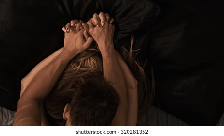 Passionate couple making love and holding hands
