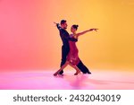 Passionate dancers. Artistic, talented young man and woman in motion in beautiful stage costumes dancing ballroom against gradient pink yellow background in neon light. Concept of dance class, art