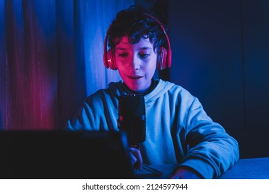 Passionate Kid Wanna Be An Influencer And Is Recording A Vlog Podcast In His Room Sitting At The Desk And Talking On The Mic And The Laptop Webcam