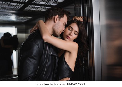 Passionate Man In Black Jacket Embracing Sexy Woman With Closed Eyes In Elevator